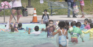 Children playing in a pool wearing bright swim suits
